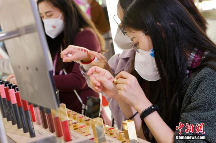 圖為女生正在體驗(yàn)口紅產(chǎn)品。 殷立勤 攝