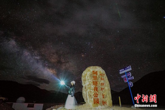圖為6月20日晚，游客“打卡”西藏阿里暗夜公園，天上是銀河與流星（右上角）。曹枝清 攝